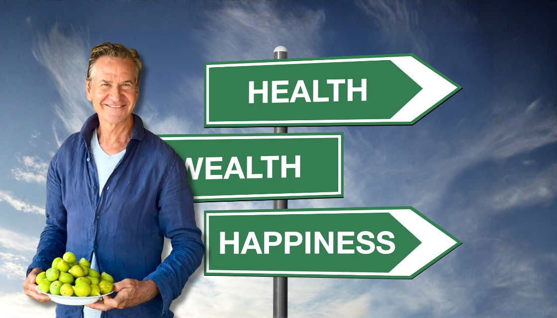 Rob Spence hält eine Schale frischer Früchte vor Wegweisern zu Health, Wealth und Happiness – ein visuelles Symbol für praktische mentale Gesundheit Tipps. Das Bild zeigt, wie bewusste Lebensentscheidungen und gesunde Routinen das mentale Wohlbefinden stärken.